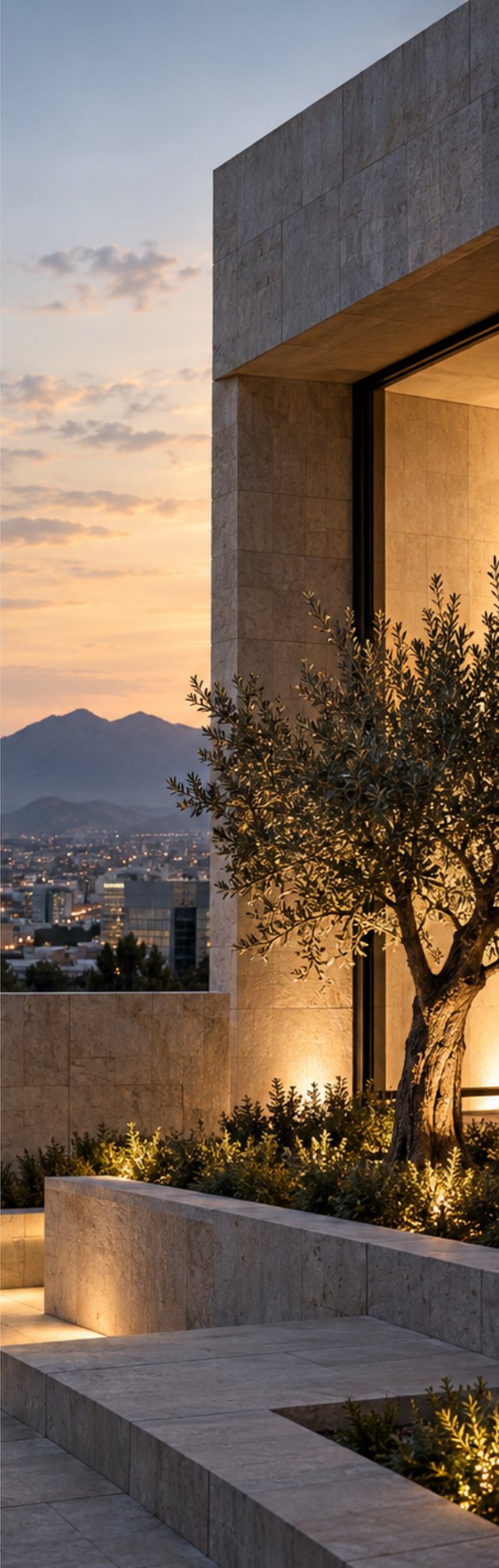 Fachada de piedra con olivo y vista a la ciudad al atardecer